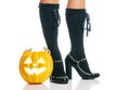 Halloween glowing pumpkin near female legs in black shoes. Royalty Free Stock Photo