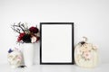 Halloween gothic romance mock up black frame on a white shelf with red and black flowers, skull and floral pumpkin