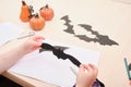Halloween handmade decor. Child makes paper bat