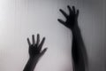 Halloween hands behind transparent glass blur background as silhouette