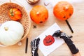 Halloween. Hands in black gloves are drawing a laughing pumpkin, on a desk.