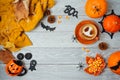 Halloween holiday background with coffee cup, pumpkin and autumn leaves on wooden table. Top view from above. Flat lay