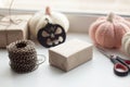 Halloween holiday background, gift box, ribbon, knitted and wooden pumpkin on the window, rustic style.