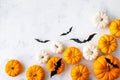 Halloween holiday background with party decorations of pumpkins and bats on white table top view. Happy halloween greeting card Royalty Free Stock Photo