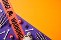 Halloween holiday banner design. Flat lay composition with skull, skeleton hands, bloody eyes, spider, tape WARNING on purple and