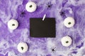 Halloween holiday blank black spiders, web, decorative white pupkins on traditional purple background. Flat lay, top view. Space