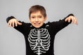 Boy in halloween costume of skeleton frightening