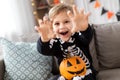 Happy boy in halloween costume of skeleton at home