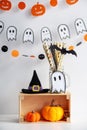 Halloween Concept. Festive decor on a white background: green phanar, crocheted pumpkins, cocktail straws, gifts Royalty Free Stock Photo