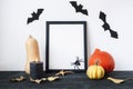 Halloween holiday concept with blank picture frame, pumpkins, candle, bats and spider on black and white background Royalty Free Stock Photo