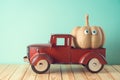 Halloween holiday concept with cute funny pumpkin decor and toy truck on wooden table Royalty Free Stock Photo