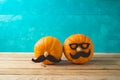 Halloween holiday concept with cute funny pumpkin decor on wooden table over blue background Royalty Free Stock Photo