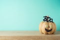 Halloween holiday concept with cute funny pumpkin decor on wooden table over blue background Royalty Free Stock Photo