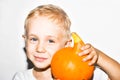 Halloween holiday concept. Cute little kid with pumpkin on a white background. Happy little boy holding a Halloween pumpkin. Royalty Free Stock Photo