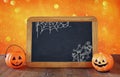 Halloween holiday concept. Cute pumpkins next to blackboard