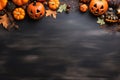 Halloween holiday concept - dried leaves and small orange pumpkins on dark background, top view, copy space