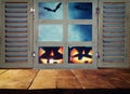 Halloween holiday concept. Empty rustic table in front of haunted night sky background and old window. Ready for product display m Royalty Free Stock Photo