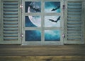 Halloween holiday concept. Empty rustic table in front of haunted night sky background and old window. Ready for product display m Royalty Free Stock Photo