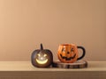 Halloween holiday concept with jack o lantern coffee cup and black pumpkin decoration on wooden table over modern background Royalty Free Stock Photo