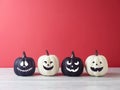 Halloween holiday concept with jack o lantern funny pumpkin decoration on wooden white table over pink background Royalty Free Stock Photo