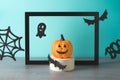 Halloween holiday concept with jack o lantern pumpkin and paper decor. Modern still life composition