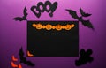 Halloween holiday concept top view. Black spiders, bats, ghost, orange paper Jack O`Lantern, pumpkins on the perple background. Royalty Free Stock Photo