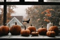 for halloween holiday, decoration with pumpkins on a windowsill, a bat and beautiful autumn landscape outside the window