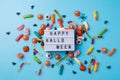 Halloween holiday decorations and sweets with lightbox with words Happy Halloween flat lay on blue background