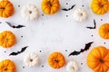 Halloween holiday frame with party decorations of pumpkins and bats on white table top view. Happy halloween greeting card Royalty Free Stock Photo