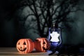 Halloween holiday with two toys pumpkin, toy lantern ghost and toy black spider on wooden table, horror background.