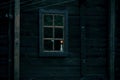 Halloween horror building. Reflection and shadows of a spooky tree in the window of an old wooden dark mystical ghostly house in