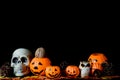 Halloween human skull, Halloween Pumpkins on an old wooden table in front of black background with free space for text Royalty Free Stock Photo