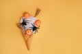 Halloween icecream made with ice-cream cone, spider web, witch\'s broom and pumpkins on orange background Royalty Free Stock Photo