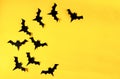 Flying black paper bats isolated on yellow background