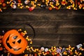 Halloween Jack o Lantern pail with double border of spilling candy over dark wood Royalty Free Stock Photo