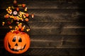 Halloween Jack o Lantern pail with side border of spilling candy over dark wood Royalty Free Stock Photo