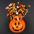 Halloween Jack o Lantern pail with spilling candy, top view on a black background Royalty Free Stock Photo