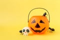Halloween Jack o Lantern plastic pumpkin bucket, spiders in the jack basket on yellow background. Royalty Free Stock Photo