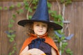 Halloween kids. funny cute smiling girl in orange witch costume, black hat with pumpkin Jack, Royalty Free Stock Photo