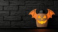 Halloween lantern with bat wings on a textured black wall background Royalty Free Stock Photo