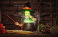 Halloween. little witch child cooking potion in cauldron with Royalty Free Stock Photo
