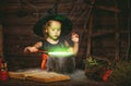 Halloween. little witch child cooking potion in cauldron with