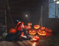 Halloween. witch child with magic wand and pumpkins Royalty Free Stock Photo