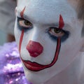 Halloween Makeup Like Pennywise. Street performer clown with a white face. The look of a man in the guise of IT on a costume