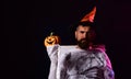 Halloween man with pumpkin in darkness. Wizard, sorcerer, warlock. Halloween man with smile on dark background. Royalty Free Stock Photo