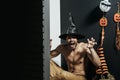 Halloween man in witch hat shouting with grabbing hands