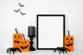 Halloween mock up black frame on a wood shelf with rustic wood jack o lantern decor, spiders and candle Royalty Free Stock Photo