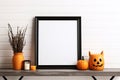 Halloween mockup, shelf with empty frame and holiday decorations. Black frame with pumpkin decor and candles, copy space. AI