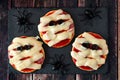 Halloween mummy mini pizzas on slate server with spiders