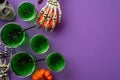 Halloween night party concept. Top view photo of green swamp punch with floating spiders straws skull skeleton hands holding